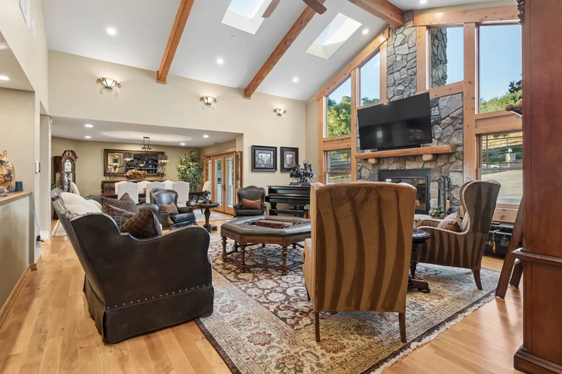 Living room with vaulted timber ceiling and stone fireplace.