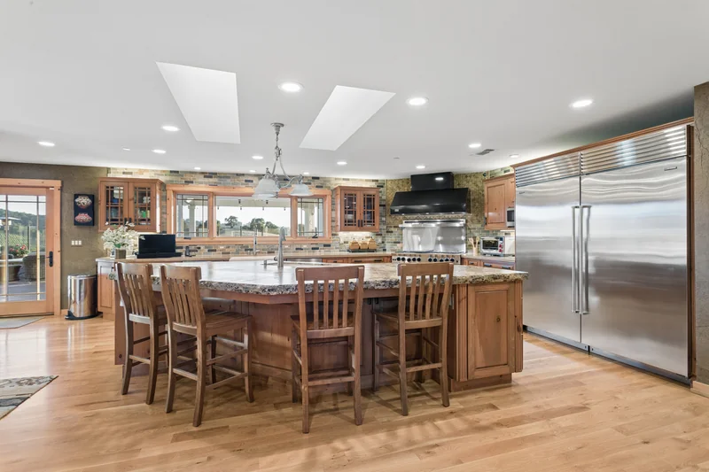 Kitchen with a large wood island and stainless steel appliances.