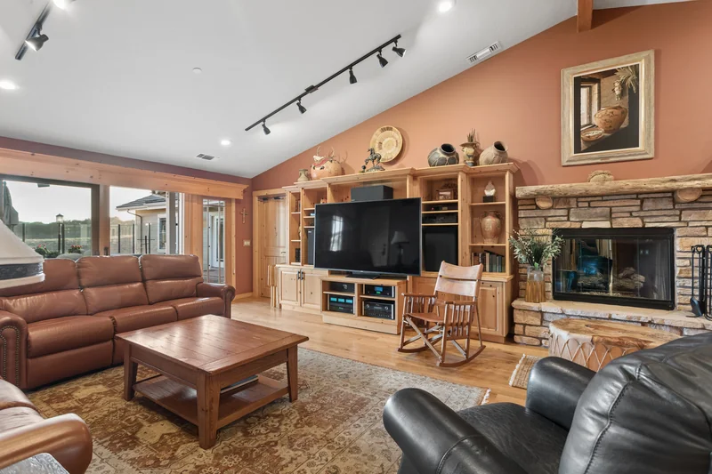 Lounge with wood floors, fireplace and leather seating.
