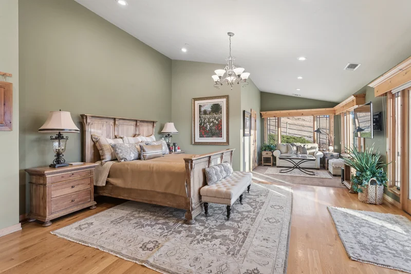 Spacious bedroom with sitting area and garden-facing doors.