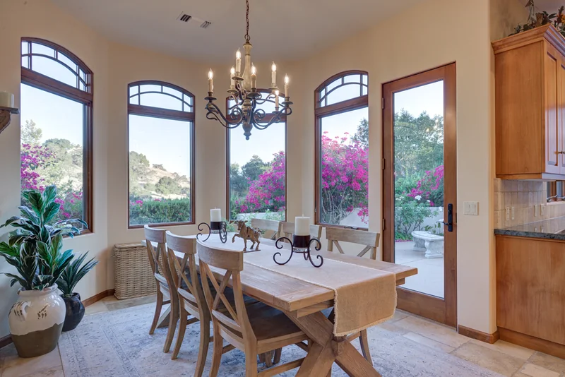 Breakfast nook with arched windows and a chandelier.