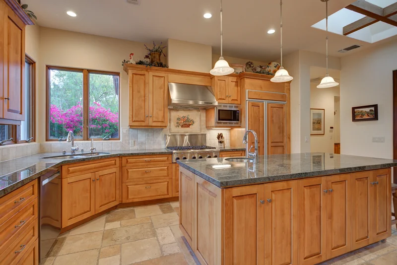 Wood kitchen island beneath skylights and recessed lighting.