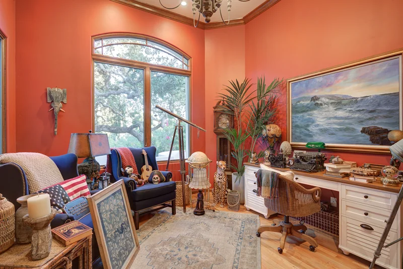 Office with tall bookshelves and a red accent wall.