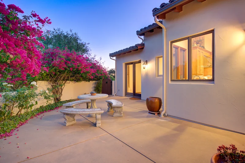 Illuminated stucco entrance framed by flowering bougainvillea.