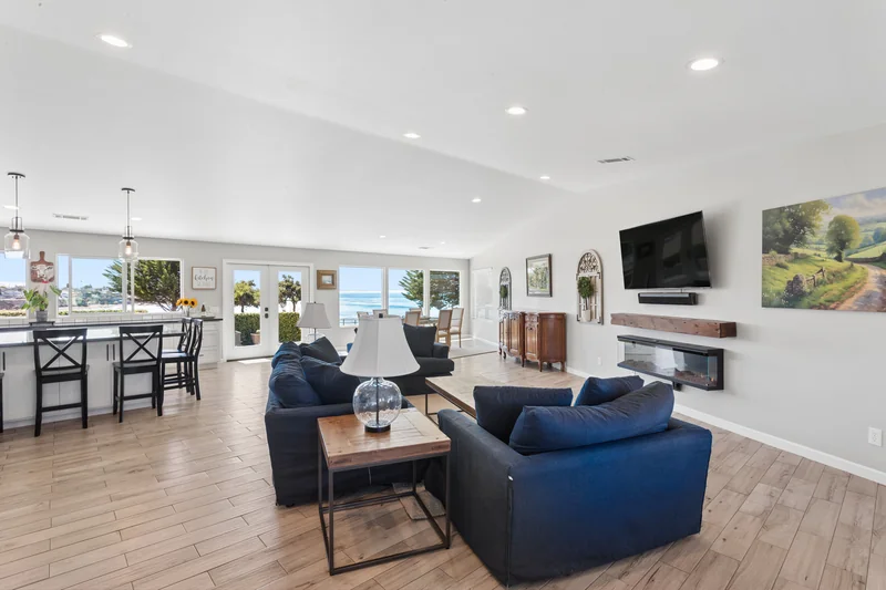 Open living room with blue seating and a bright adjoining kitchen.