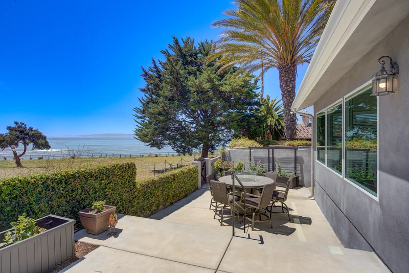 Outdoor dining patio overlooking palms and the ocean.