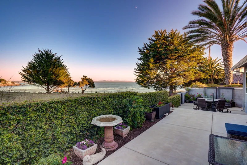 Coastal patio seating overlooking the ocean at sunset.