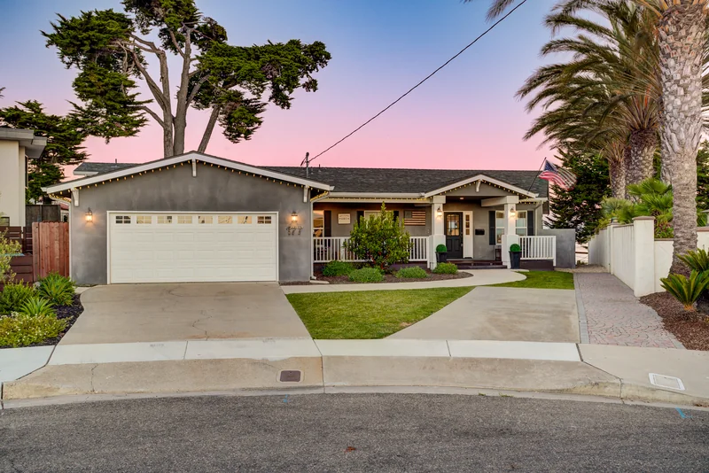 Palm-framed front exterior beneath a pink twilight sky.