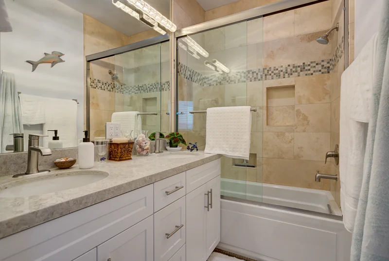 Bathroom vanity beside a glass-enclosed stone shower.
