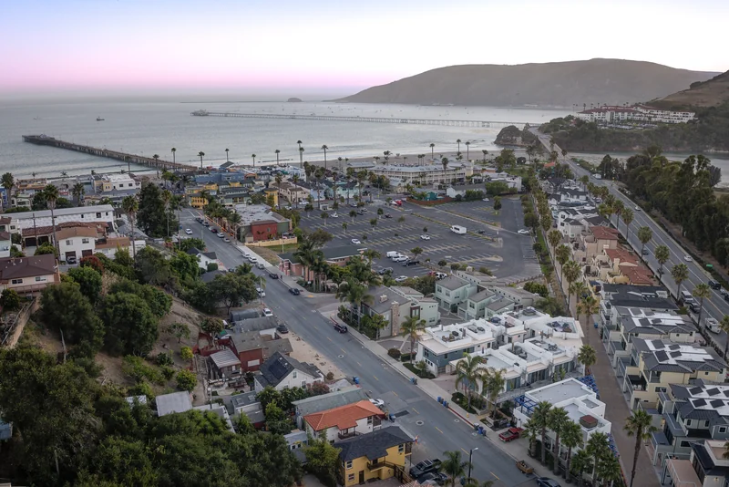 Coastal neighborhood and bay viewed from above at dusk.