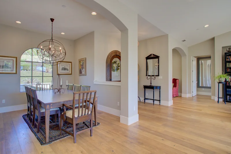 Dining room with a chandelier and arched passageways.