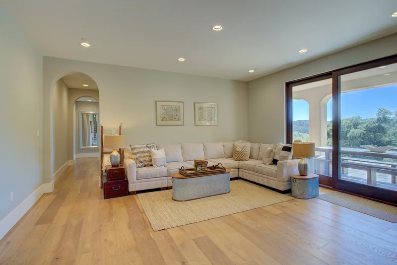 Light-filled living room with cream seating and sliding doors.